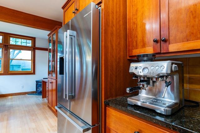 1043 Lincoln Ave, Saint Paul, MN 55105 - kitchen featuring high quality fridge, brown cabinets, baseboards, dark stone countertops, and light wood-style floors