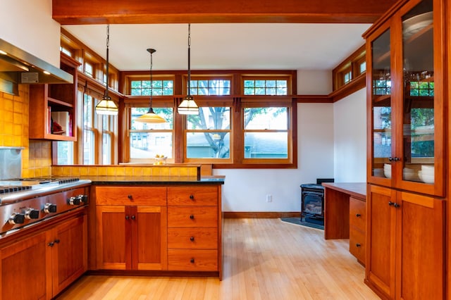 1043 Lincoln Ave, Saint Paul, MN 55105 - kitchen featuring a wood stove, light wood finished floors, baseboards, brown cabinetry, and hanging light fixtures
