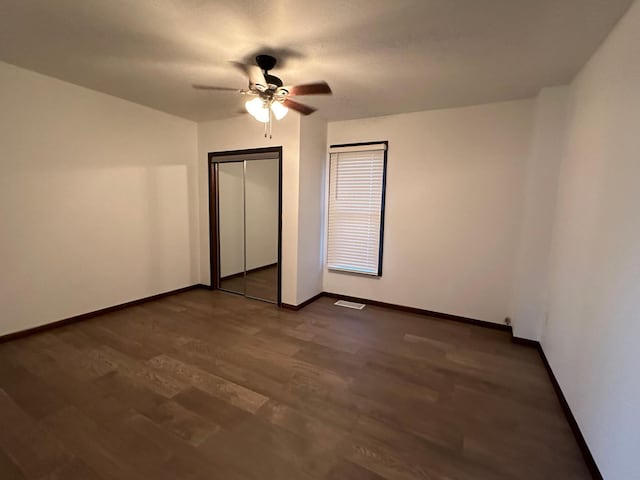 15 1st St SE, Melrose, MN 56352 - unfurnished bedroom with visible vents, a closet, baseboards, ceiling fan, and dark wood finished floors