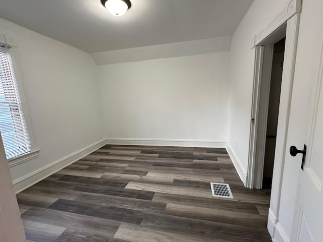 15 1st St SE, Melrose, MN 56352 - unfurnished bedroom featuring baseboards, visible vents, lofted ceiling, and dark wood-type flooring