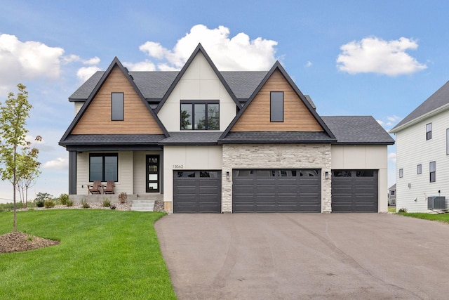 craftsman house with roof with shingles, a front yard, central air condition unit, covered porch, and driveway