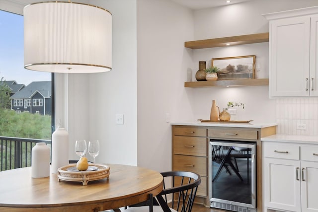 dining space featuring beverage cooler and recessed lighting