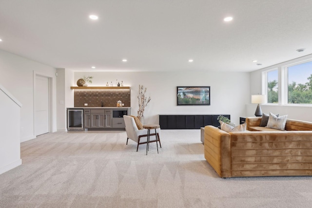 living area featuring indoor wet bar, recessed lighting, wine cooler, and light colored carpet
