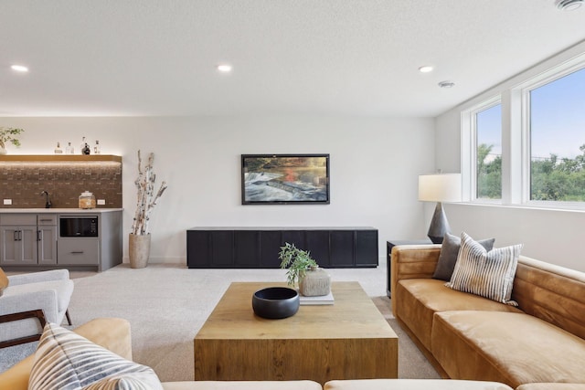 living room featuring carpet floors, recessed lighting, and indoor wet bar