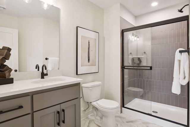 bathroom with vanity, marble finish floor, toilet, baseboards, and a stall shower
