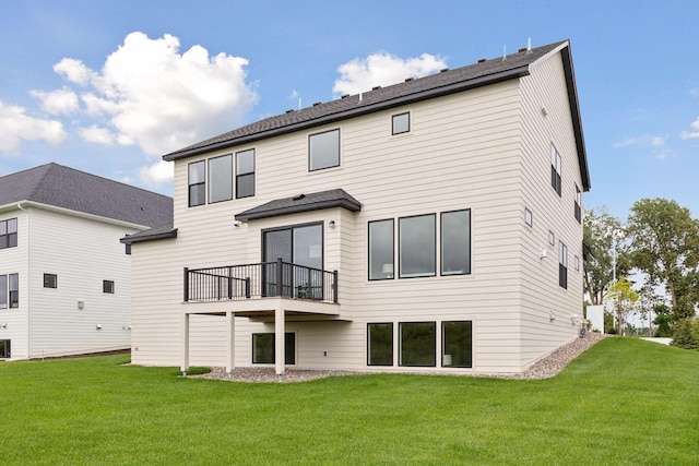 rear view of property with a lawn and a balcony