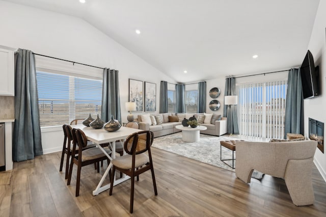 dining room featuring recessed lighting, light wood-style flooring, and lofted ceiling