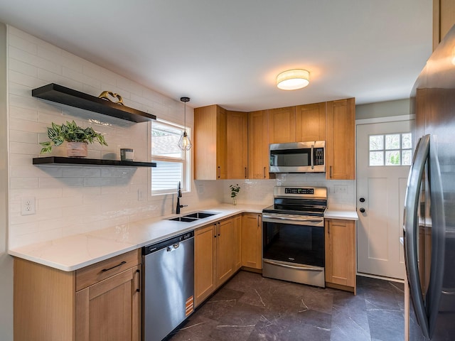 kitchen featuring open shelves, appliances with stainless steel finishes, light stone countertops, a sink, and backsplash