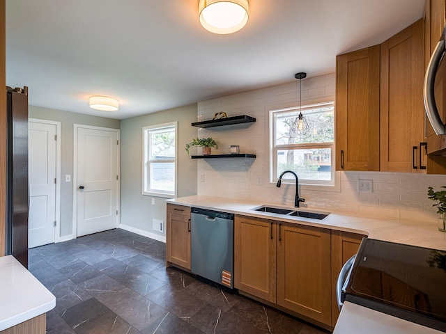 kitchen with stainless steel dishwasher, decorative backsplash, brown cabinetry, baseboards, and a sink