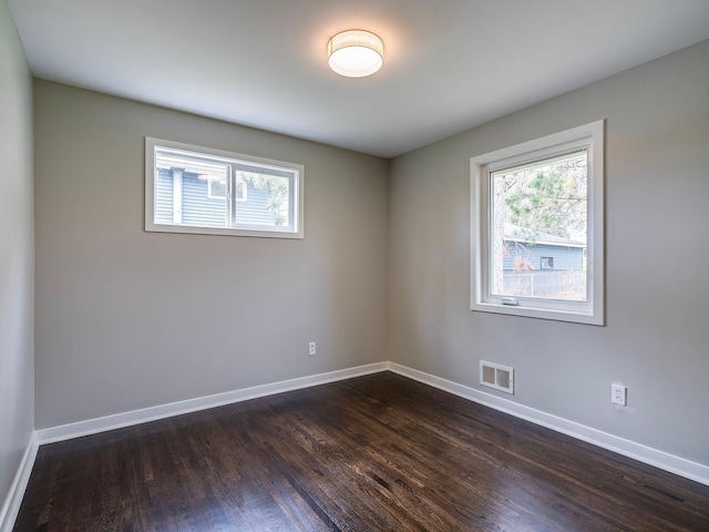 unfurnished room featuring visible vents, baseboards, and a wealth of natural light