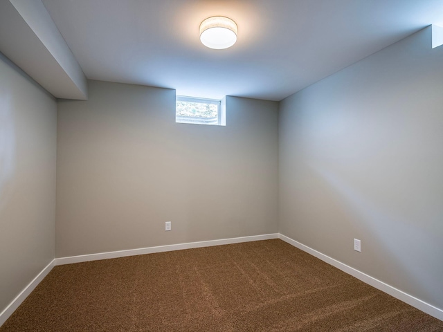 below grade area with dark colored carpet and baseboards