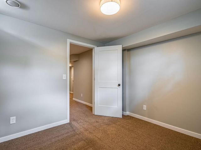 carpeted empty room featuring baseboards