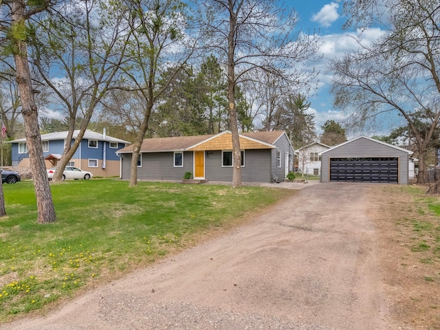 ranch-style home featuring a detached garage, an outbuilding, and a front yard