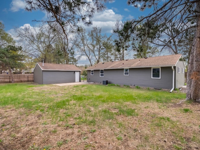back of house with an outdoor structure, fence, a yard, and a detached garage