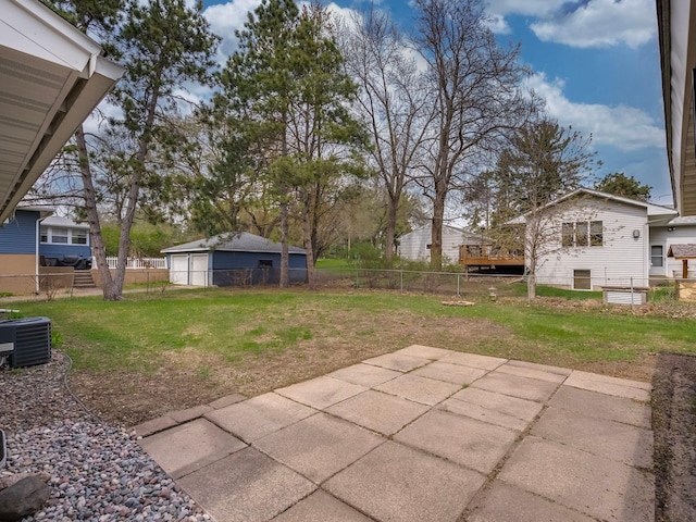 view of yard with a patio, a garage, a fenced backyard, and central AC unit
