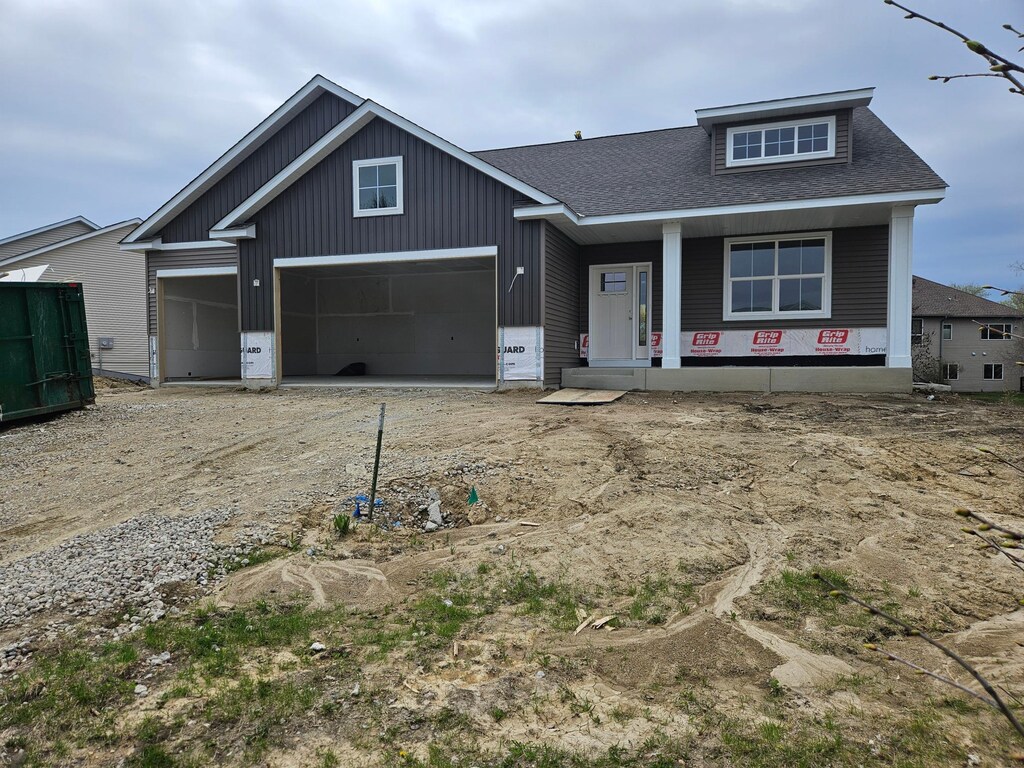 view of front of house featuring a garage, covered porch, a shingled roof, board and batten siding, and driveway