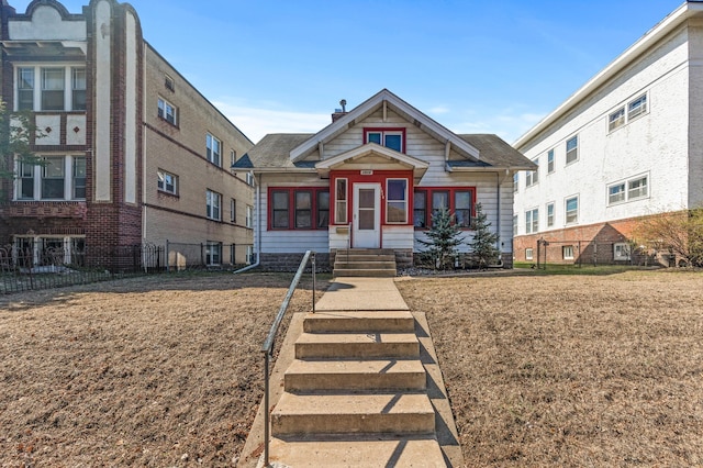 bungalow-style home with fence, a chimney, and entry steps