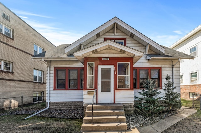 view of front of house featuring fence and roof with shingles