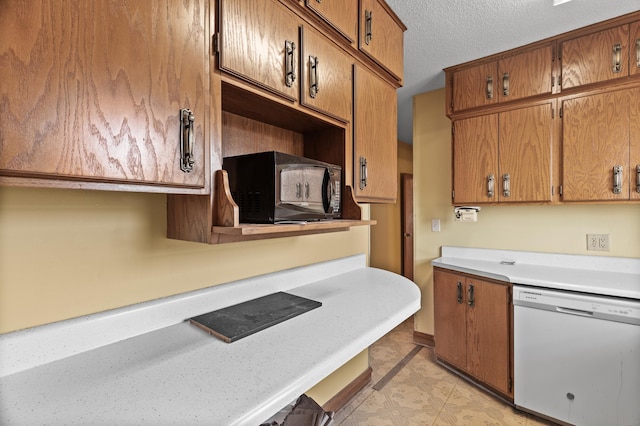 kitchen featuring light floors, light countertops, a textured ceiling, brown cabinets, and dishwasher