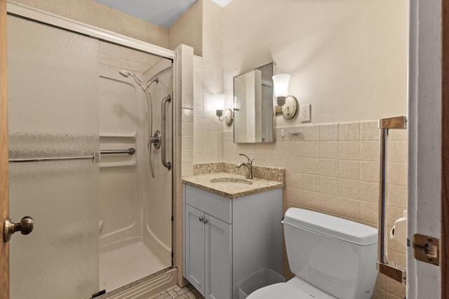 full bath featuring vanity, tile walls, a stall shower, and toilet