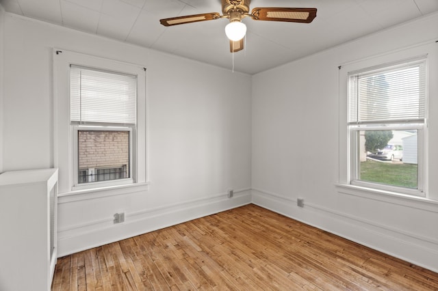 spare room with light wood-type flooring and a ceiling fan