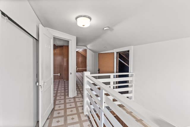 hall featuring light floors and vaulted ceiling