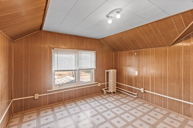 bonus room featuring wooden walls, tile patterned floors, vaulted ceiling, and radiator heating unit