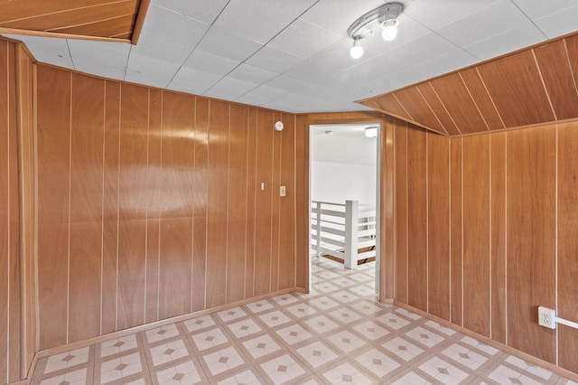 interior space with tile patterned floors and wood walls