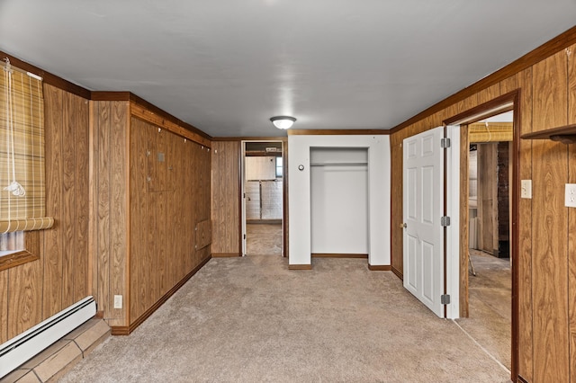 interior space with baseboards, wood walls, light carpet, and baseboard heating