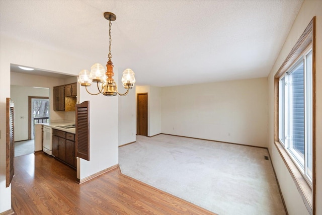 interior space with an inviting chandelier, light wood-style flooring, and a wealth of natural light