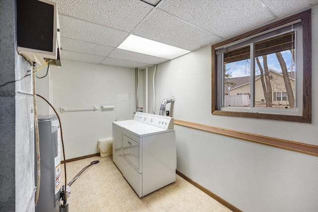 laundry room with baseboards, washer and clothes dryer, and water heater