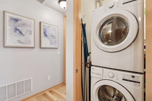 3640 Wooddale Ave S Unit 317, Saint Louis Park, MN 55416 - washroom with stacked washer / dryer, wood finished floors, and baseboards