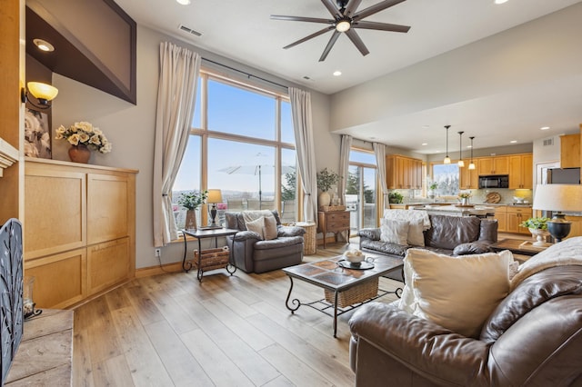 living room with ceiling fan, recessed lighting, baseboards, light wood-type flooring, and visible vents