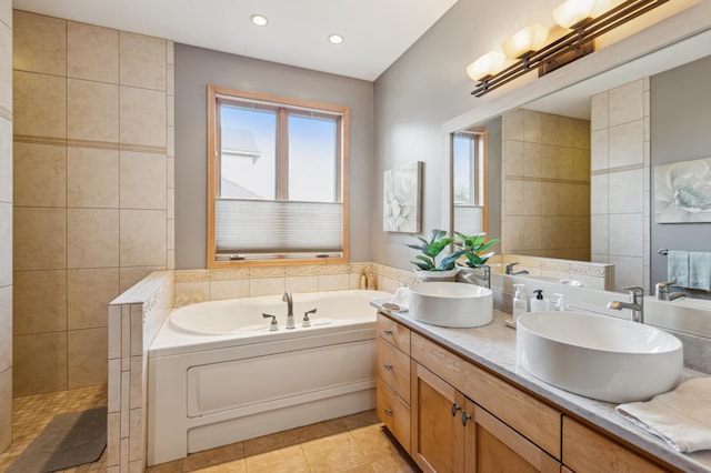 full bath featuring a sink, tile patterned flooring, double vanity, recessed lighting, and a garden tub