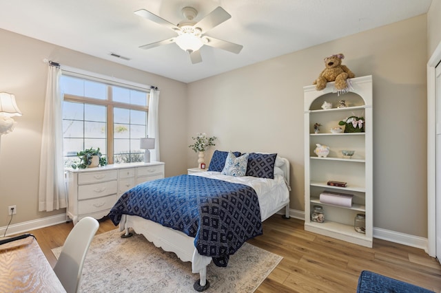bedroom featuring ceiling fan, baseboards, visible vents, and light wood-style flooring