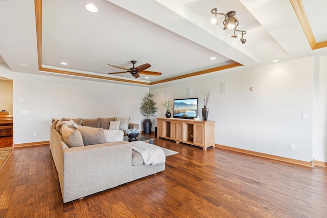living room with baseboards, a ceiling fan, a raised ceiling, and hardwood / wood-style flooring