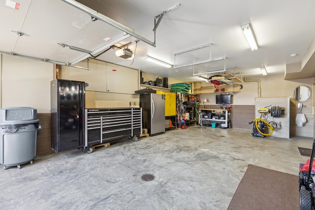 garage with freestanding refrigerator and a garage door opener