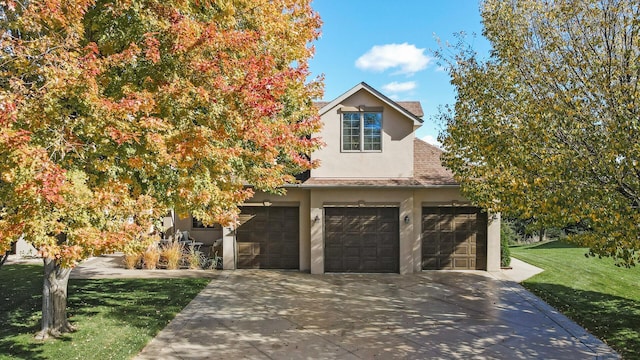 view of front of home featuring a garage, a front yard, roof with shingles, stucco siding, and driveway