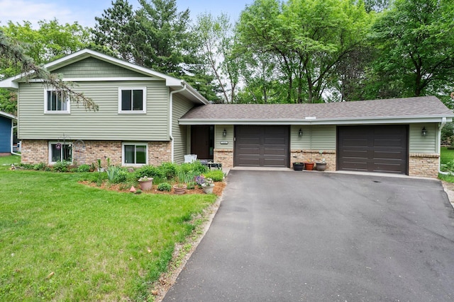216 Richard Ave SE, Isanti, MN 55040 - tri-level home with a garage, a front yard, asphalt driveway, and brick siding