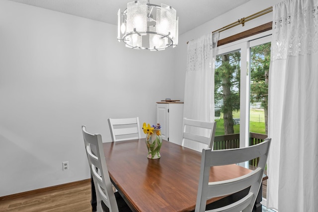 216 Richard Ave SE, Isanti, MN 55040 - dining room with a chandelier, wood finished floors, and baseboards