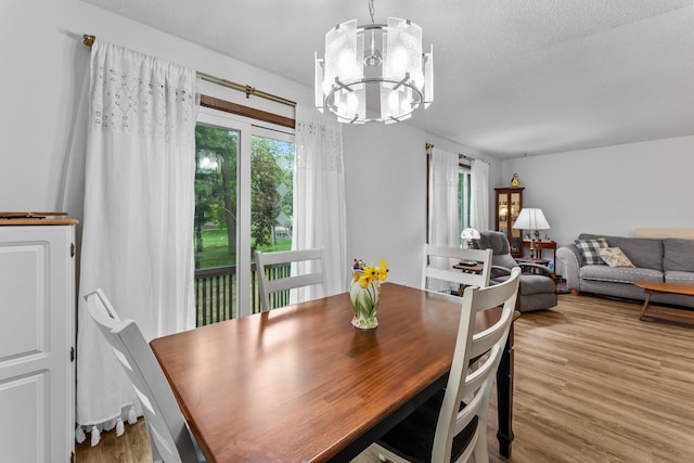 216 Richard Ave SE, Isanti, MN 55040 - dining area featuring a chandelier, wood finished floors, and a textured ceiling