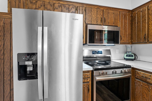 216 Richard Ave SE, Isanti, MN 55040 - kitchen featuring appliances with stainless steel finishes, light countertops, and brown cabinets