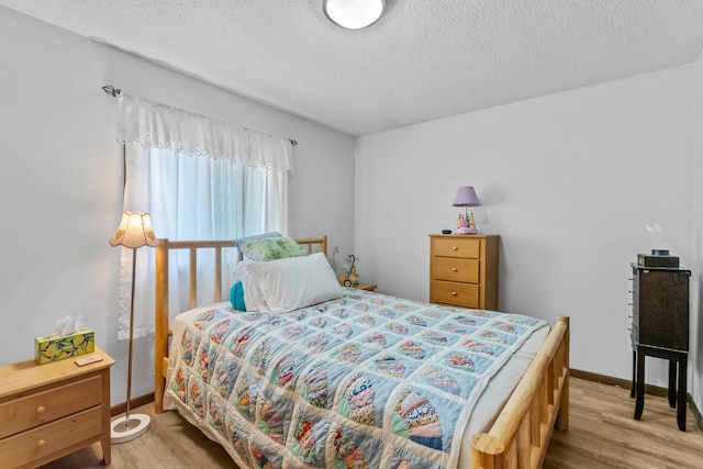 216 Richard Ave SE, Isanti, MN 55040 - bedroom with wood finished floors, a textured ceiling, and baseboards