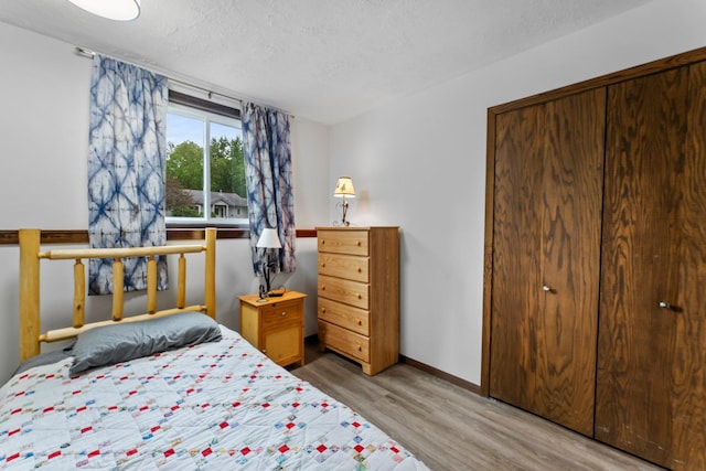 216 Richard Ave SE, Isanti, MN 55040 - bedroom featuring light wood finished floors, baseboards, and a textured ceiling