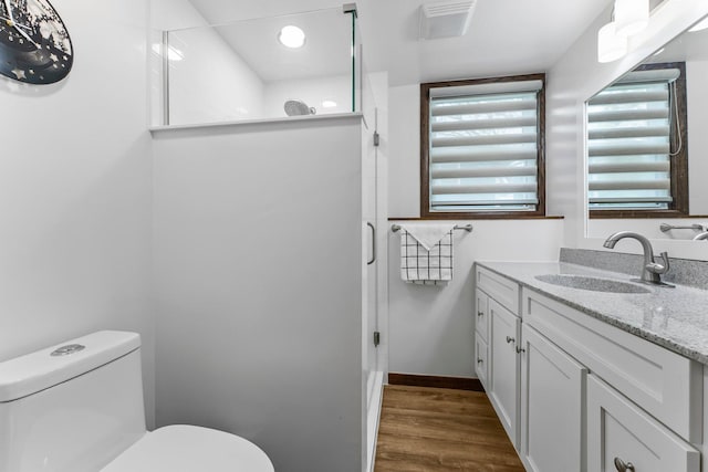 216 Richard Ave SE, Isanti, MN 55040 - full bathroom featuring vanity, a stall shower, toilet, and wood finished floors
