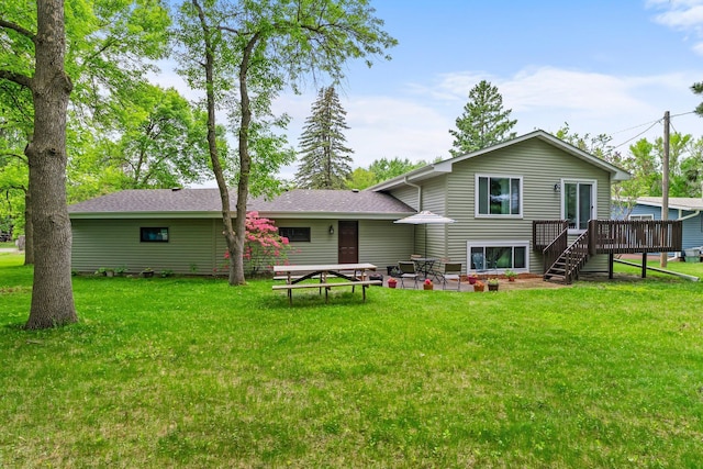 216 Richard Ave SE, Isanti, MN 55040 - rear view of property featuring a deck, a lawn, a shingled roof, and a patio