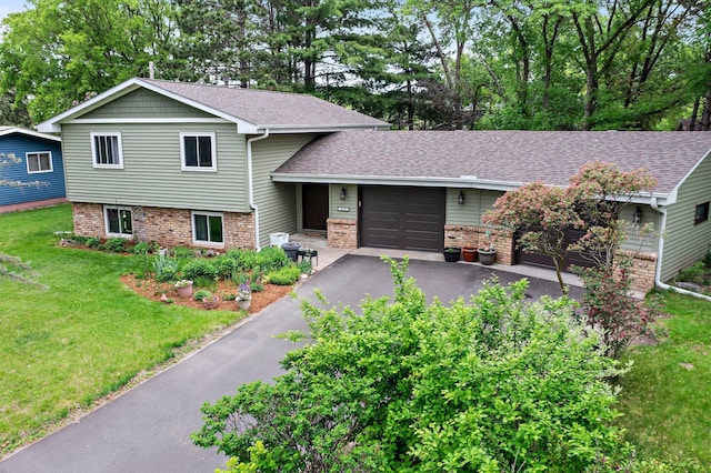 216 Richard Ave SE, Isanti, MN 55040 - tri-level home with a garage, asphalt driveway, brick siding, and a front yard