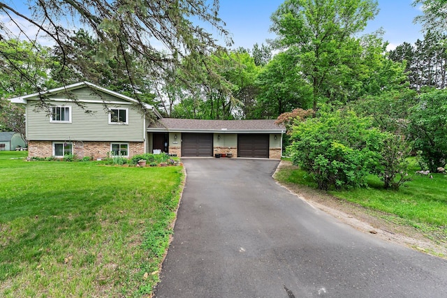 216 Richard Ave SE, Isanti, MN 55040 - tri-level home featuring an attached garage, brick siding, asphalt driveway, and a front yard