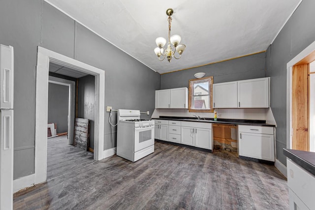 107 6th Ave SE, Waseca, MN 56093 - kitchen featuring white cabinets, dark countertops, an inviting chandelier, a sink, and white range with gas cooktop