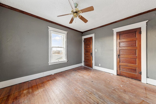 107 6th Ave SE, Waseca, MN 56093 - spare room with crown molding, ceiling fan, a textured ceiling, hardwood / wood-style floors, and baseboards